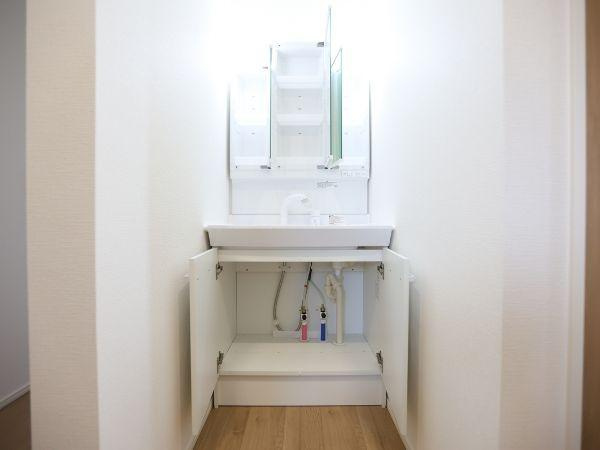 挾間町下市2期9号棟の独立洗面台|洗面台下の収納スペースが広く日用品の整理がしやすいです。三面鏡タイプで使い勝手が良い洗面台です。シンプルなデザインでどんな空間にも合わせやすいです。明るい印象の内装で気持ちよく使えます。