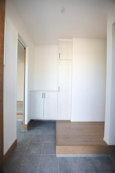 挾間町下市2期9号棟の玄関|明るさを感じる玄関スペースです。シンプルで整ったデザインが特徴です。収納が設けられているためすっきりとした印象です。床面の切り替えが動線のアクセントになっています。