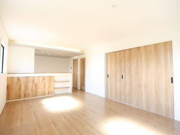 挾間町下市2期9号棟の居間・リビング|リビングは明るい陽射しが差し込む空間です。木目調のフローリングと扉が統一感のある印象を与えます。シンプルな内装でお好みに合わせてコーディネートできます。収納スペースも確保されすっきりとした印象です。