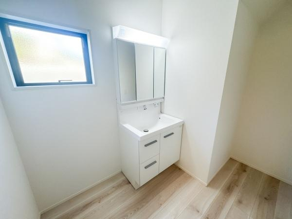 羽屋4丁目1期1号棟の独立洗面台|明るい空間に設置された洗面台が清潔感を演出しています。窓付きで換気もしやすく毎日の使い勝手に配慮されています。木目調の床材がシンプルながらも空間に落ち着きを加えています。