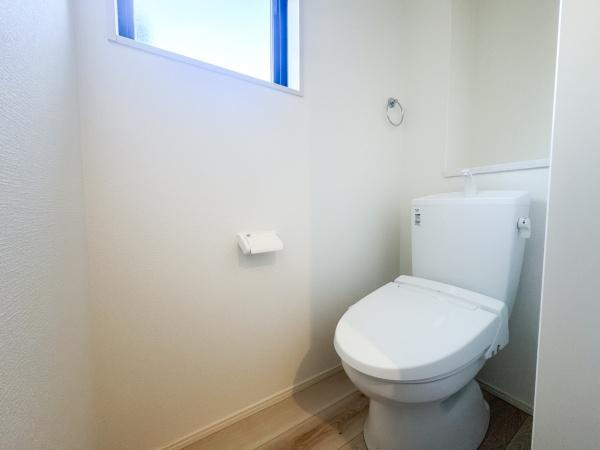 羽屋4丁目1期1号棟のトイレ|シンプルなデザインのトイレで清潔感があります。明るい窓から採光が取れるので空間が開放的です。壁や床もナチュラルなトーンで統一され落ち着いた雰囲気になっています。手洗い付きで機能面も考えられています。