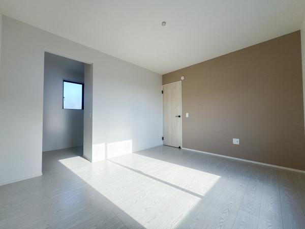 羽屋4丁目1期1号棟の洋室|明るい陽射しがたっぷりと差し込む洋室です。ナチュラルな色合いの床が落ち着いた雰囲気を演出します。シンプルな内装でお手入れもしやすい設計です。壁のアクセントカラーが室内空間に調和を加えています。