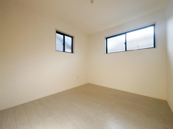 羽屋4丁目1期1号棟の洋室|2面に窓があり室内が明るく開放的に感じられます。シンプルなフローリングがすっきりとした印象です。家具の配置もしやすい洋室です。落ち着いた色合いの壁が空間をより広く見せています。