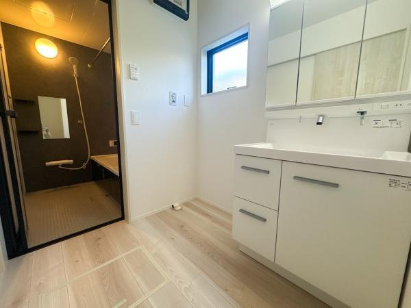 羽屋4丁目1期1号棟の独立洗面台|明るい洗面台・洗面所は清潔感があります。収納も充実しており使いやすい空間です。窓からの自然光がしっかりと差し込みます。バスルームも隣接していて動線が良好です。床材の質感も魅力的です。