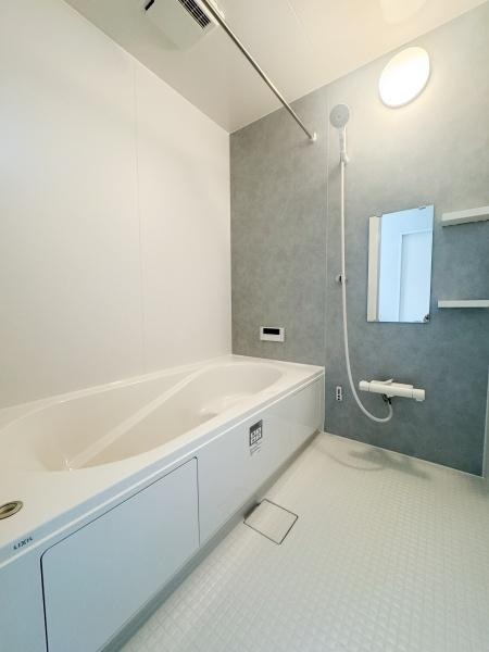 大字森町3期1号棟の浴室|浴槽がゆったりとした造りでお手入れしやすい壁面が特徴です。鏡や棚が備え付けられており使い勝手に配慮されています。床は滑りにくい仕様で安心してご利用いただけます。