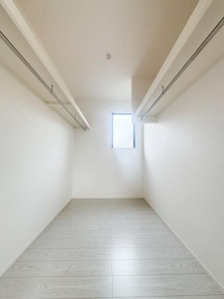 大字森町3期1号棟の収納|明るい窓付きの収納スペースです。室内はすっきりとした印象で使いやすい形状となっています。両側にハンガーパイプが設置されており整理しやすい設計です。