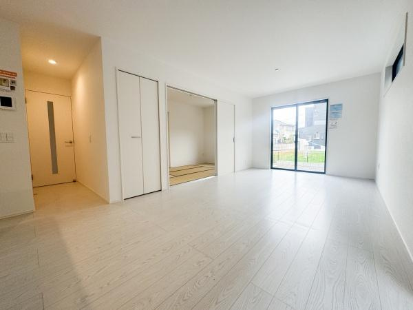 大字森町3期1号棟の居間・リビング|リビングは白を基調とした明るい空間です。窓からたっぷり自然光が入ります。畳スペースもリビングに隣接しています。収納も備わっていて便利です。清潔感のある床が印象的です。