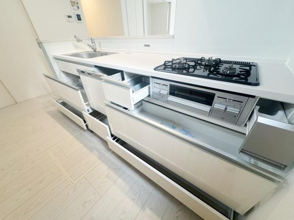 大字森町3期1号棟のキッチン|キッチン全体に収納スペースが豊富に設けられているので整理整頓がしやすいです。白を基調としたデザインで清潔感があります。ガスコンロとシンクが使いやすい配置です。調理や片付けも効率よく行えそうです。