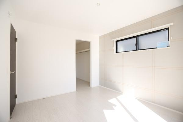 大字荏隈2期2号棟の洋室|シンプルで落ち着いたデザインの部屋。アクセントのストライプ壁紙が特徴で、収納スペースも確保された使い勝手の良い空間です♪自然光が差し込み、明るく開放感のある印象です！