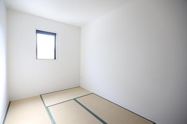大字荏隈2期2号棟の和室|シンプルなデザインの和室です。窓から自然光が差し込み明るい空間になっています。畳が敷かれており落ち着いた雰囲気を感じられます。壁や天井もすっきりと仕上げられています。