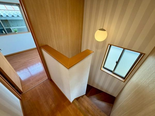 【その他】 | 階段には明るい窓があり通気性にも配慮されています。手すりもしっかりとしており安全性が感じられます。落ち着いた木目調の内装が特徴です。照明が空間をやさしく照らします。