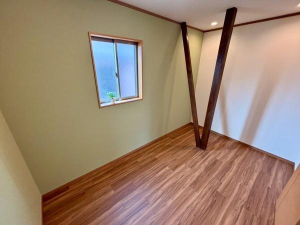 【洋室】 | 木目調のフローリングが落ち着いた雰囲気の洋室です。アクセントになる梁が特徴的でシンプルながら個性を感じられます。窓から自然光が入りやすく室内を明るく保てます。