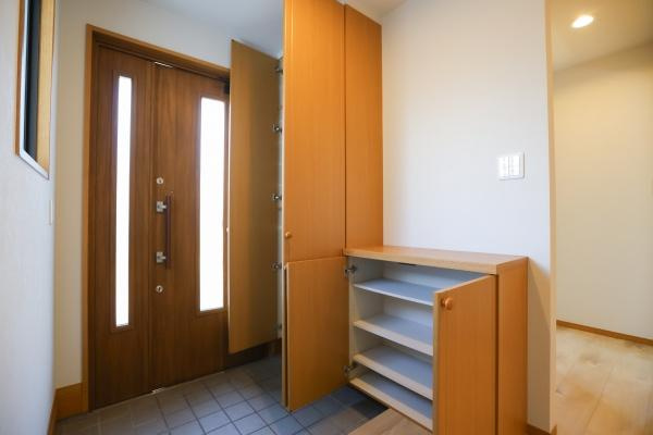 田尻南二丁目　中古の玄関|玄関には収納スペースが豊富に備わっており靴や小物をすっきりと収納できます。明るい木目調の扉が落ち着いた印象です。タイル張りの床でお手入れも簡単です。廊下への動線もスムーズに確保されています。