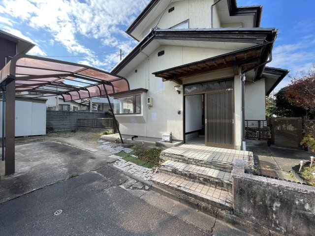 須賀川市和田弥六内　中古戸建　第三小・第三中の玄関|玄関脇にある駐車場。縦列2台も可能ですが、奥のフェンスを撤去し駐車場スペース増設も可能です。