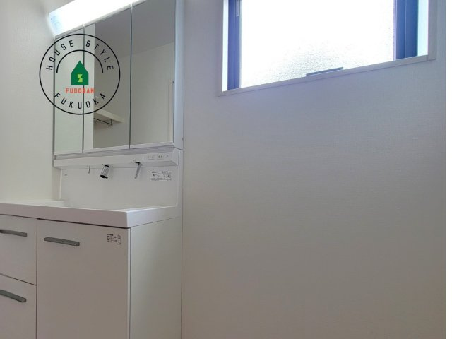 古賀市天神7丁目第5-2棟（2号棟）の内観：施工例|毎日使うものだから清潔な空間を保ちたい水回り。洗面にはそんな願いを解消させてくれる収納アイデアが満載です。三面鏡の裏側にはキャビネットが現れ小物から背の高い物まで収納できます。