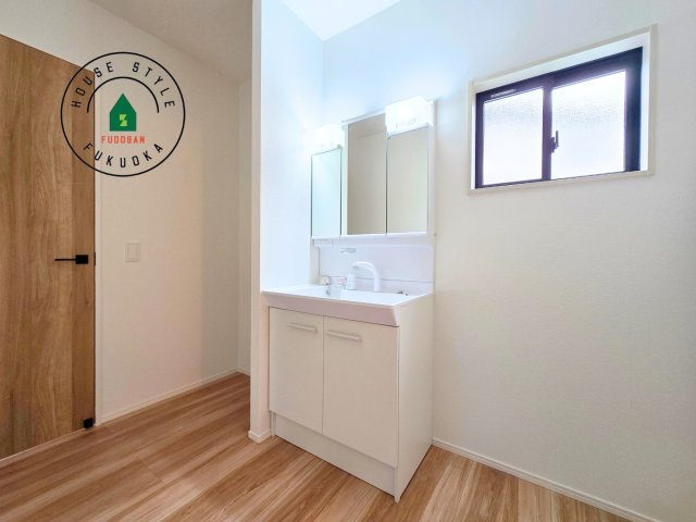 古賀市花見南3丁目第4-1棟（1号棟）の内観：施工例|毎日使うものだから清潔な空間を保ちたい水回り。洗面にはそんな願いを解消させてくれる収納アイデアが満載です。三面鏡の裏側にはキャビネットが現れ小物から背の高い物まで収納できます。