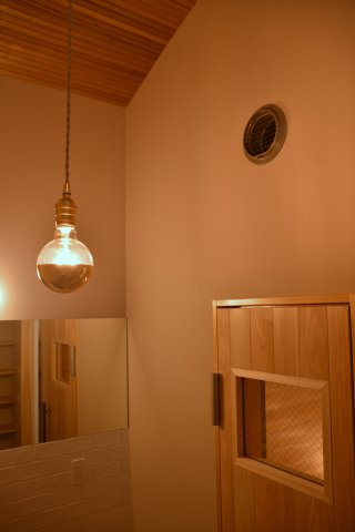 サウナ付き賃貸「サ民家」ととのう町家の洗面所|サウナへの入口。曲線の天井を柔らかい光が照らし出します。