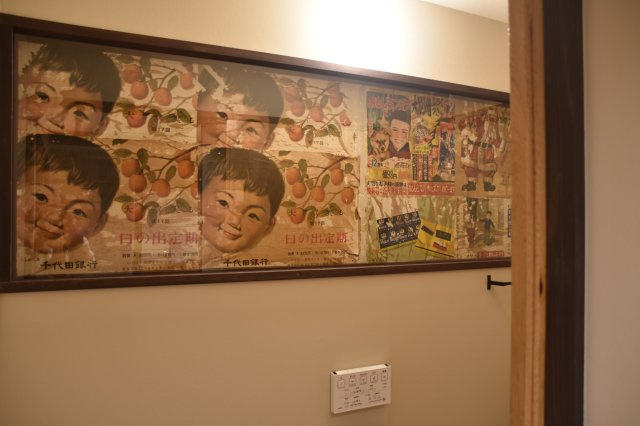 サウナ付き賃貸「サ民家」ととのう町家のトイレ|トイレの壁には遊び心が。改装前の壁に貼られていた昔のチラシをそのまま残し、
額縁をつけてアートに。