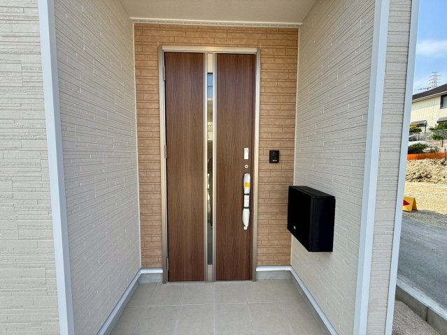 クレイドルガーデン中城村添石 第１・２号棟の玄関|屋根付きで置き配スペースも確保できる玄関ポーチ／人感センサー付き玄関灯・TVモニター付きインターフォン・防犯カメラ