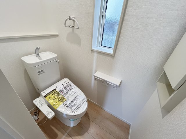 高知市薊野西町１丁目　新築一戸建て　のトイレ|温水洗浄つきのトイレ。壁面収納でスッキリした印象。