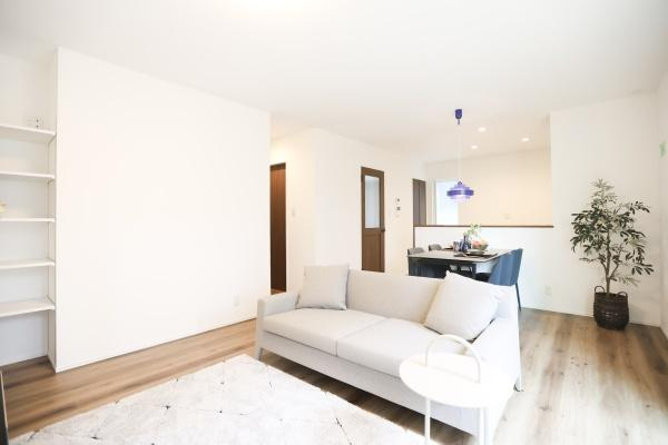 中鶴崎Ｗ　新築の居間・リビング|白を基調としたリビングが明るく開放感があります。ナチュラルな木目調のフローリングが温かみを感じさせます。壁面の収納棚は整理整頓に便利です。家具の配置もしやすいシンプルな間取りです。