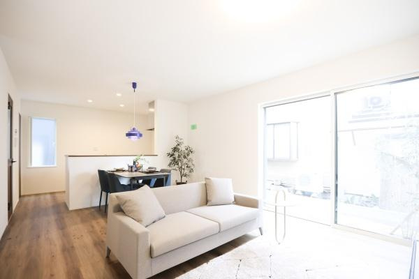 中鶴崎Ｗ　新築の居間・リビング|ナチュラルなフローリングとホワイトの壁が調和したリビングです。大きな窓から自然光がしっかり入ります。シンプルなインテリアが開放感を演出しています。ダイニングテーブルやソファも配置しやすい広さです。