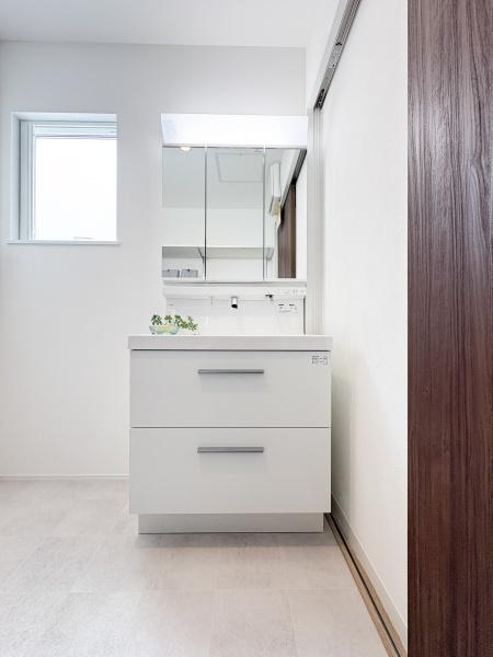 中鶴崎Ｗ　新築の独立洗面台|収納力のある引き出しが特徴の洗面台です。シンプルで清潔感のあるデザインが魅力的です。鏡裏にも収納スペースがあり小物の整理に役立ちます。木目調の扉が空間にアクセントを加えています。