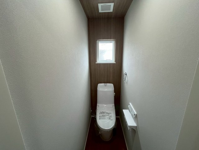 山形市東青田三丁目のトイレ|温かみのある木目調天井と奥の壁がアクセント。落ち着きと高級感を両立したレストルーム。