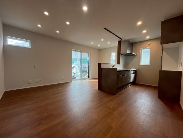 山形市東青田三丁目の居間・リビング|ダウンライトが優しく照らす洗練されたLDK。木目の温もりとモダンなキッチンが調和する心地よい空間。