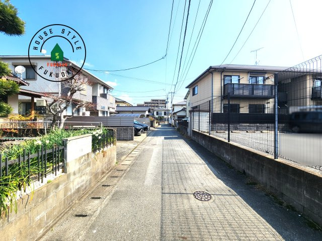 大野城市山田2丁目第1-2棟（1号棟）の前面道路含む現地写真|前面道路は閑静な住宅地をはしる車通りの少ない道路。お車の出し入れが苦手なママや小さなお子様にも安心ですね。しっかり舗装もされているので、ベビーカーや自転車で通っても快適に通行できます。