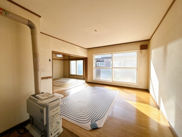 【居間・リビング】 | 北見市中ノ島町３丁目１３番７号　中古売家 | 【リフォーム前】リビング写真です。壁、天井クロスの貼替、床はクッションフロア上張りを行います。照明器具も交換致します。古いストーブは撤去致します。