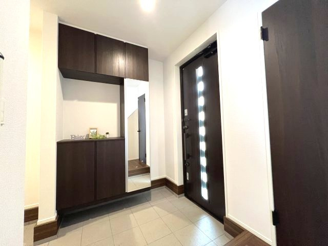 あきる野市小川東1丁目　新築戸建全1棟の玄関|天井までの高さがあるタップリ玄関収納、姿見付きなのも便利
