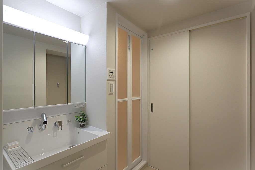 西宮グリーンマンション2号館の独立洗面台|3面鏡の明るい洗面化粧台で、毎朝の支度もはかどります。 鏡裏と洗面台下にも収納があり、日用品やスキンケア用品などもたくさんしまえてすっきりとした空間を保つことができます。