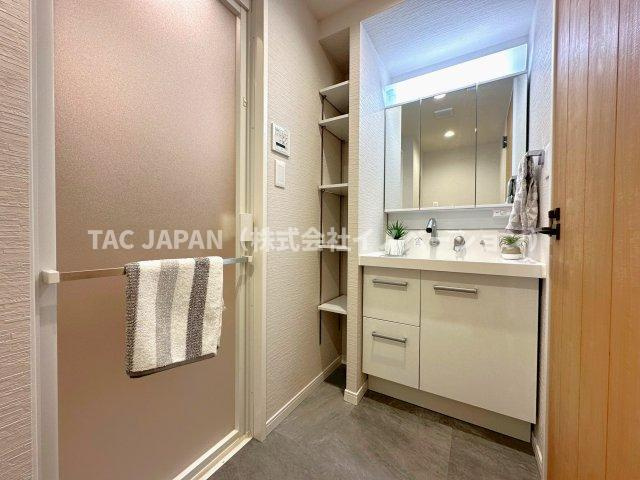 ダイアパレス西巣鴨Ⅱの洗面所|大型の洗濯機を置いても余裕が感じられる脱衣スペースにはお洒落な洗面ユニットを制作。着替えやタオル、洗剤の買い置きなどリネン庫の使い方はお客様しだい。