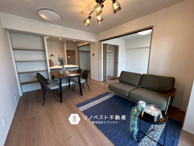 東大阪サンハイツの居間・リビング|リビング棚があり収納にも役立ちます！洋室との仕切りの扉を開けておくと広々とした空間になりますね♪