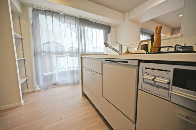 グランドハイツ甲陽園のキッチン|キッチンの奥の方から撮影した写真です。キッチンのすぐ横には収納棚も設けてあるので、パントリーのように食材を収納したり、リビングダイニングを彩るインテリアを飾ったりできます。