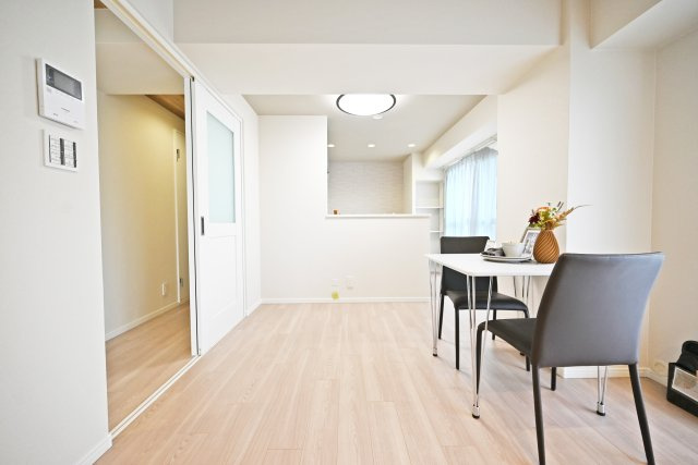 グランドハイツ甲陽園の居間・リビング|リビングからキッチンに向かって撮影した写真です。家具の配置がしやすい形状となっており、ソファセットやダイニングテーブルを置いても余裕の広さです。
