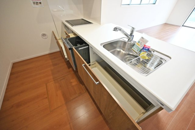 テラシエ食満3丁目新築一戸建て│4LDK+駐車並列2台可のキッチン|キッチン天板下いっぱいに収納庫を設けてあります。シンクした収納庫にはナイフホルダーも標準搭載。食器洗い乾燥機や浄水器一体型水栓も標準仕様のユニットが導入されています。