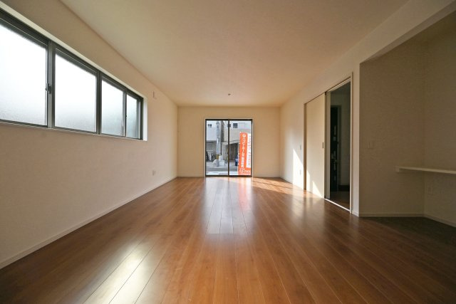 テラシエ食満3丁目新築一戸建て│4LDK+駐車並列2台可の居間・リビング|1階LDKをキッチン側から正面に撮影した内観写真です。奥行きがある縦長リビングなので、収納や家具の配置、インテリアコーディネートがしやすいです。