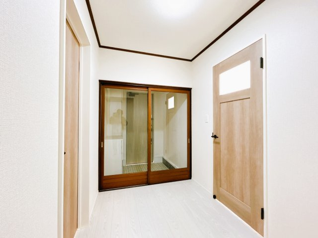 北見市北進町２丁目７番４号　中古売家のその他共用部分|【リフォーム済】1階廊下です。床と壁紙は張替えを行い、ドアも新品の物に交換致しました
