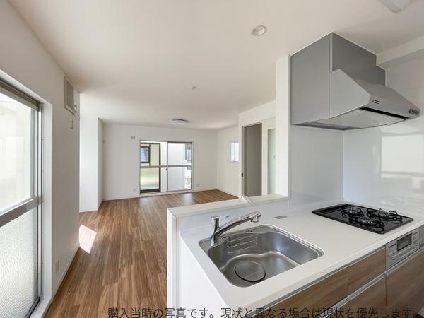 大在中央　中古の居間・リビング|大きな窓から光が差し込む開放感のあるリビングです。キッチンと一体のレイアウトで使いやすさが感じられます。ナチュラルなフローリングが落ち着いた雰囲気を演出しています。