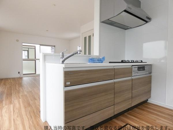 大在中央　中古のキッチン|木目調のデザインが印象的なキッチンです。明るい室内に調和したシンプルなレイアウトになっています。収納スペースも豊富に備えています。