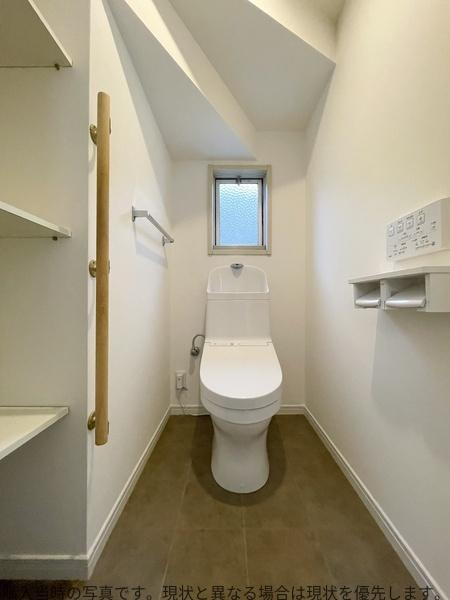 大在中央　中古のトイレ|トイレはシンプルで清潔感があります。壁際に設けられた棚は小物の整理に便利です。ホワイトを基調とした空間で明るい印象を受けます。