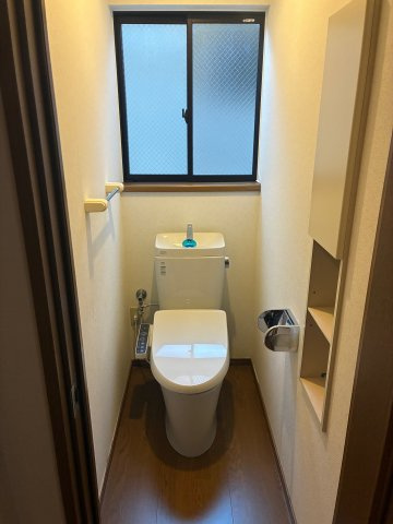 畑原通1丁目中古戸建のトイレ|毎日、使う場所だからこそこだわりを。清潔感のある白の便器に、予備のペーパーを置ける手洗いも備えた、デザインと機能性が両立したトイレです。