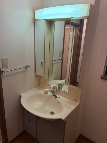 畑原通1丁目中古戸建の独立洗面台|空間に馴染むシンプルなデザインの洗面化粧台。身支度に便利な三面鏡タイプで、鏡裏には小物をすっきり整理できる収納スペースを備えています。