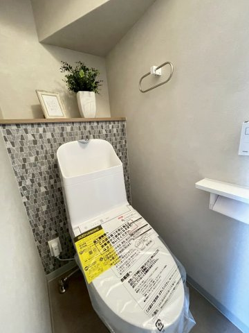 向日市上植野町御妙林のトイレ|温水洗浄便座付きトイレ。背面にはカウンターがございます。