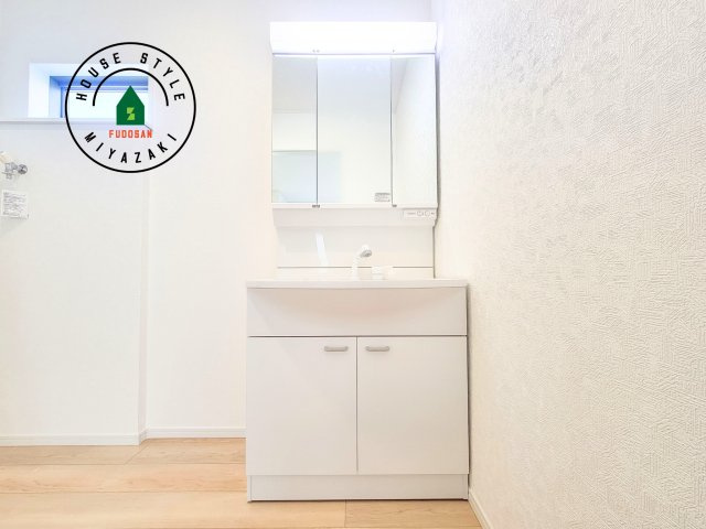 都城市都北町第1-3棟（1号棟）の内観：施工例|毎日使うものだから清潔な空間を保ちたい水回り。洗面にはそんな願いを解消させてくれる収納アイデアが満載です。三面鏡の裏側にはキャビネットが現れ小物から背の高い物まで収納できます。