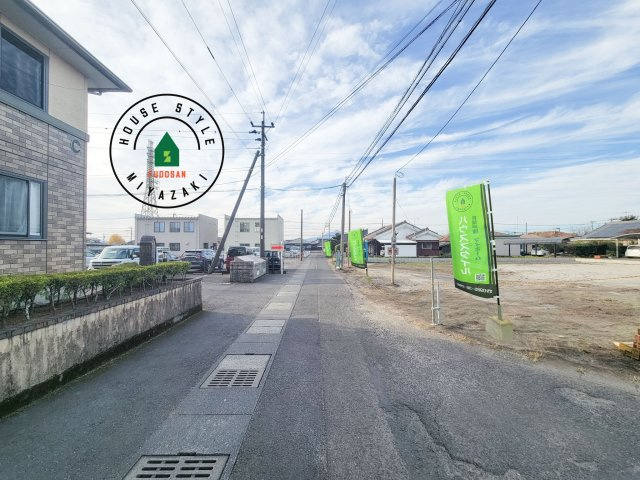 都城市都北町第1-3棟（1号棟）の前面道路含む現地写真|前面道路は閑静な住宅地をはしる車通りの少ない道路。お車の出し入れが苦手なママや小さなお子様にも安心ですね。しっかり舗装もされているので、ベビーカーや自転車で通っても快適に通行できます。