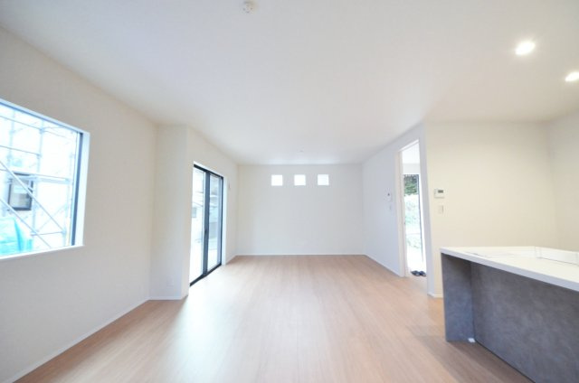 上安七丁目の居間・リビング|南西向きで窓の多いリビング空間。オープンタイプの対面式キッチンでリビングが隅まで見渡せます。キッチンにいながら小さなお子様にも目が届き安心です。