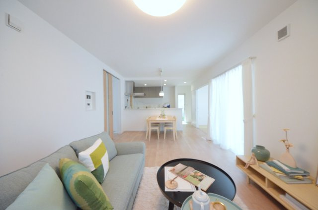 皆賀一丁目の居間・リビング|南西向きで陽当たりが良く、窓の多いリビング空間。オープンタイプの対面式キッチンでリビングが隅まで見渡せます。キッチンにいながら小さなお子様にも目が届き安心です。